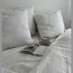 Ruhiges Morgenritual mit Kaffee und Buch im gemütlichen Bett für erschöpfte Mamas