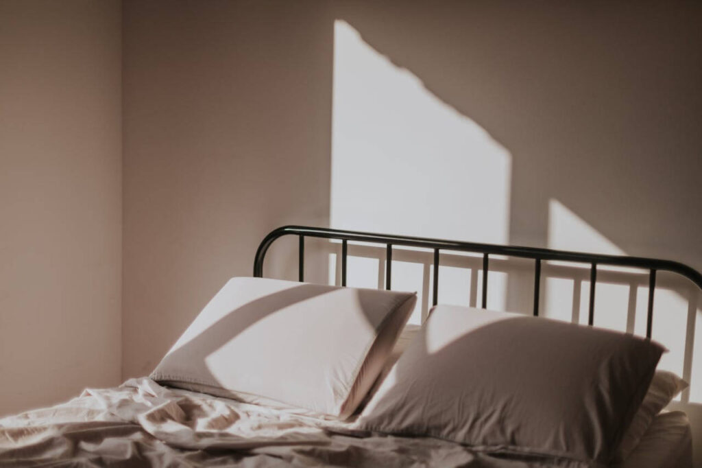 Gemachtes Bett im Morgenlicht als Symbol für Schlaf und Erholung im Mama-Alltag